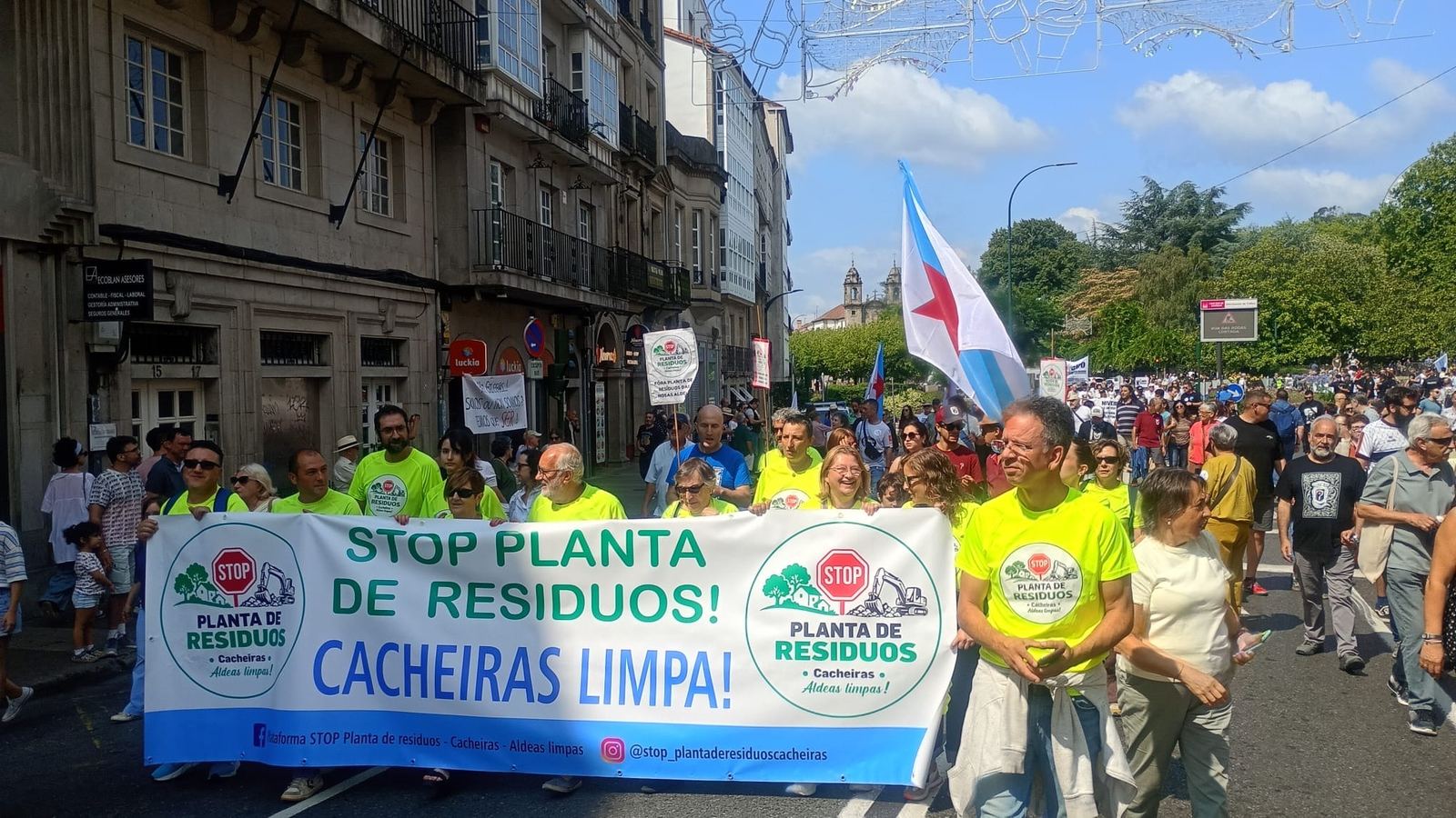A pancarta «STOP planta de residuos! Cacheiras limpa!» avanzando por unha rúa de Santiago.